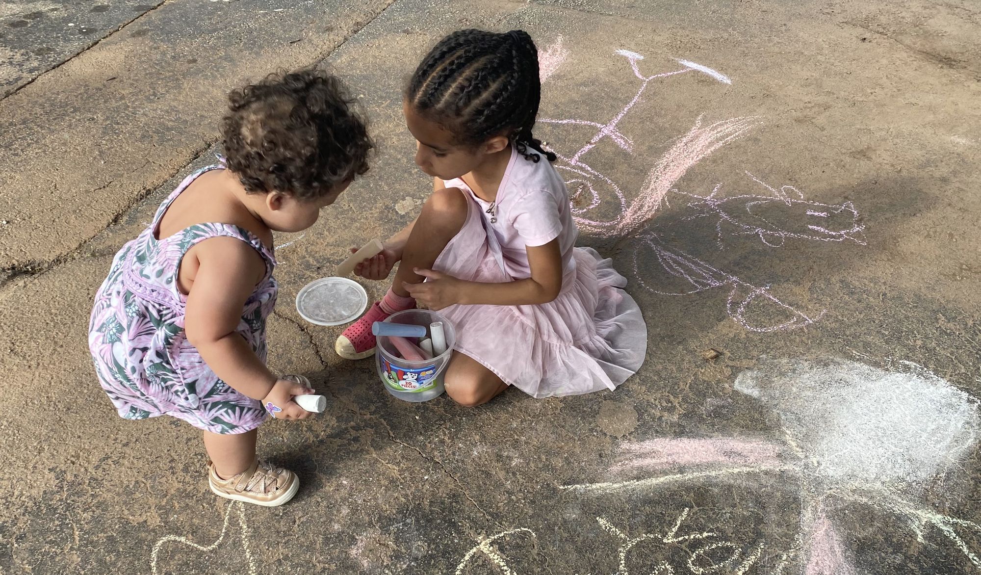 Two children drawing with chalk.